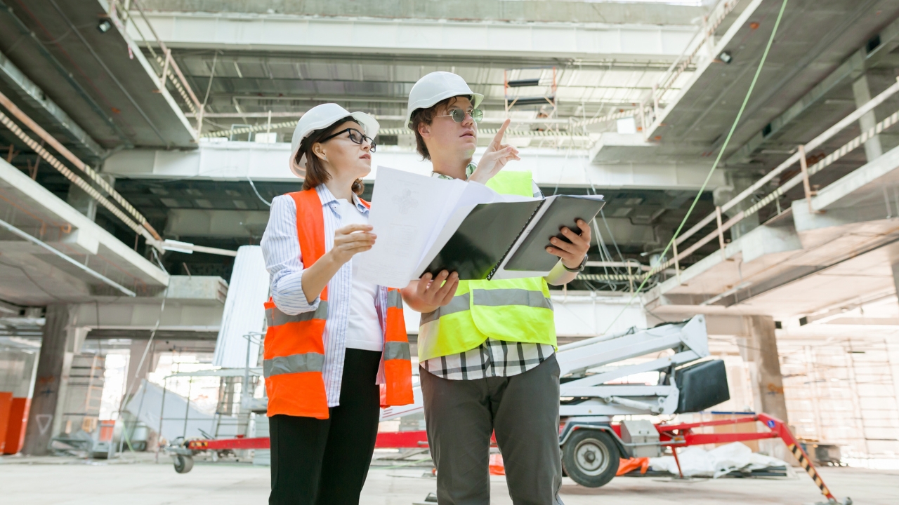 Mujer en sitio de construcción viendo un plano