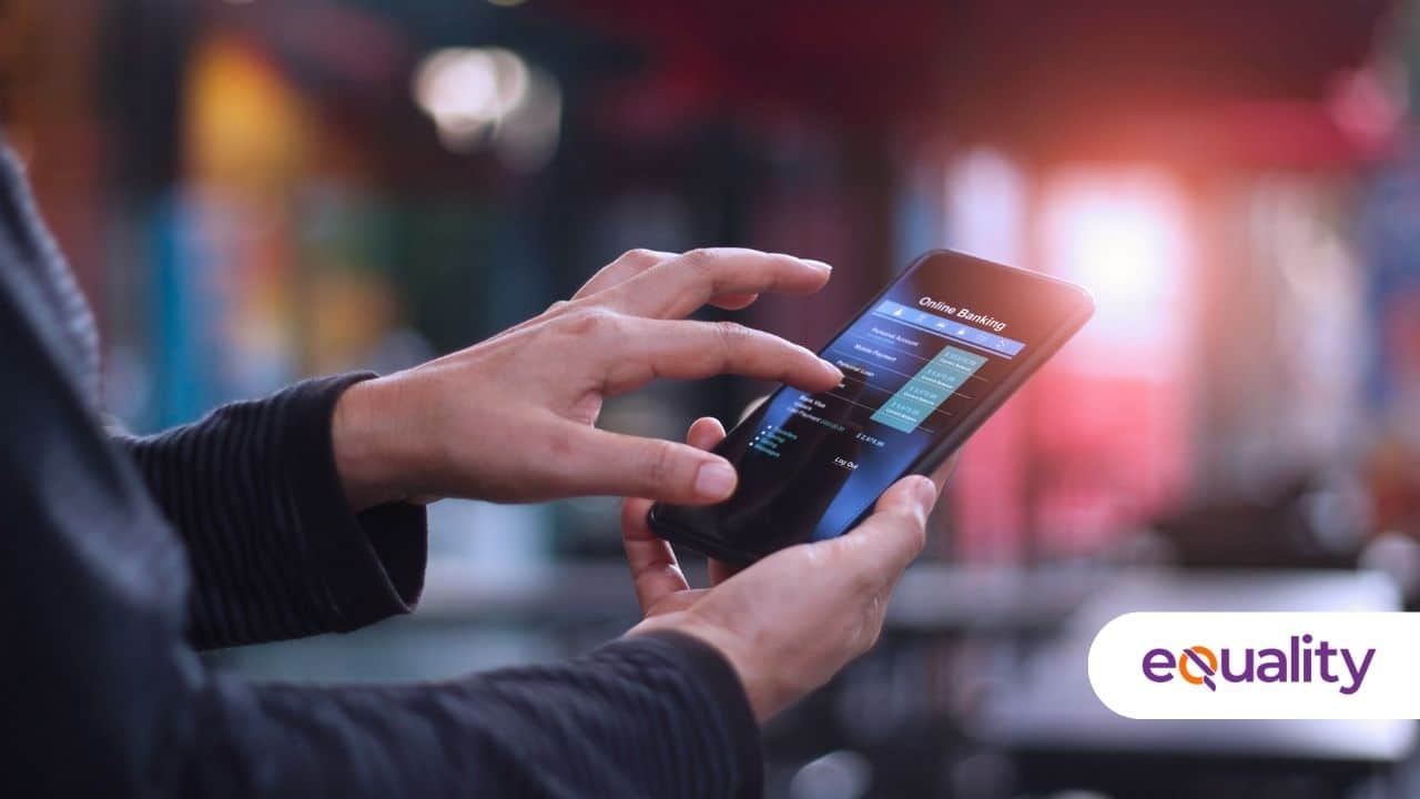 Hombre de traje con celular en la mano y app de banco en pantalla